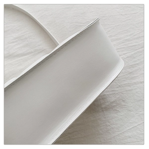 Close-up of precise stitching and premium matte texture on the white minimalist handbag