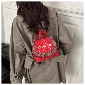 Detail of red polka dot mini backpack with plaid ruffles and 3D floral accents