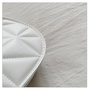Detailed view of white quilted leather texture with premium diamond stitching pattern