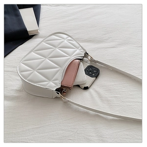 Detail of white quilted handbag interior showing capacity with a wallet and device