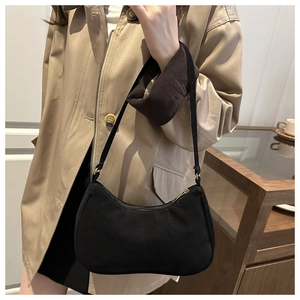 Modella che indossa una borsa hobo nera con zip dorata e tracolla regolabile