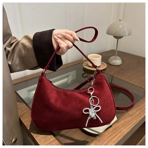 Dettaglio della borsa hobo in camoscio bordeaux con ciondolo a cuore in metallo argento