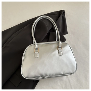 Detail shot of silver Boston bag with pleated faux leather on a brown blazer coat