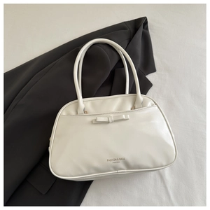 Detail of off-white leather pillow bag featuring a chic bow and FANYISSA branding