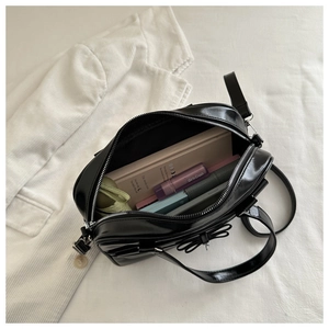 Top-down view of spacious interior of black bow handbag with daily essentials