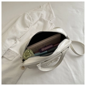 Overhead view showing large capacity and internal storage of the white bow handbag