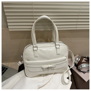 Chic beige crossbody bag with a 3D bow detail shown in a cozy lifestyle setting