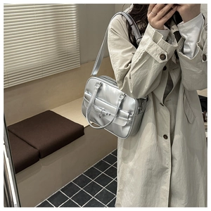 Detail of silver metallic tote bag with decorative bow and adjustable shoulder strap