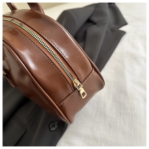 Detailed close-up of the vintage brown oil wax leather bag with golden metal zipper hardware