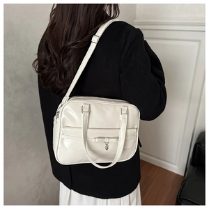White PU leather shoulder bag with a bow and silver heart pendant shown on model