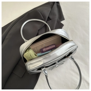 Interior storage capacity of the silver bow shoulder bag showing daily essentials