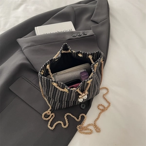 Classic woven tweed bucket bag with pearl charms and gold chain strap in top view