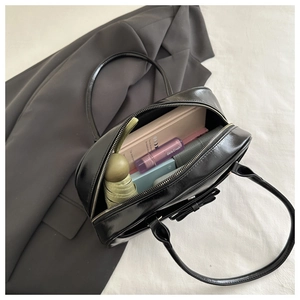 Interior view of black glossy shoulder bag showing ample space for daily essentials