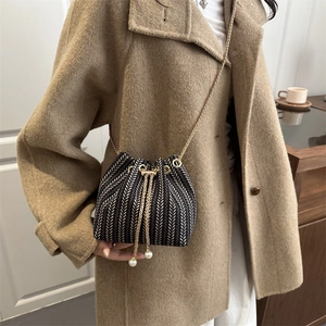Elegant black and white striped bucket bag with gold chain strap and pearl drawstring
