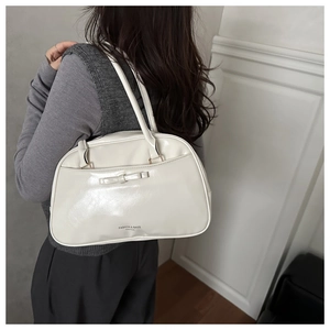 Detail of white glossy bowling bag with a bow and Fashion & Bags printed logo