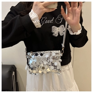 Close-up of sparkling silver sequin texture and chain strap on a stylish crossbody bag