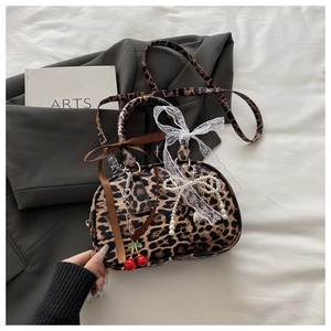 Detail of leopard print handbag with cherry charms, pearl chains and lace bows decoration