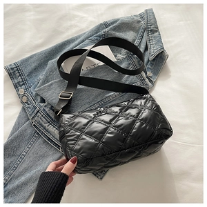 Close-up of black quilted puffer crossbody bag with wide strap on a white background