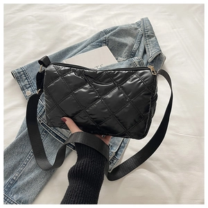 Detail of black quilted puffer bag showing glossy nylon texture and gold zipper hardware