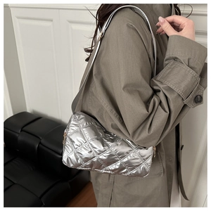 Detail of silver quilted shoulder bag with metallic finish and gold side zipper