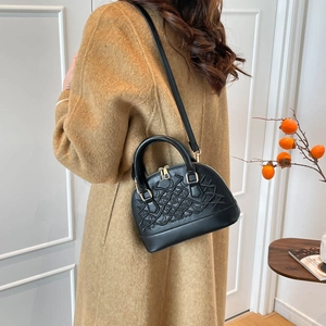 Women's black shell-shaped handbag with embossed woven texture and gold zippers