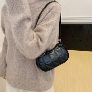 Minimalist black crescent shoulder bag with geometric embossed leather and gold hardware