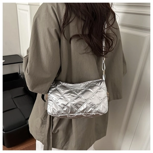 Close-up of metallic silver quilted shoulder bag with detailed diamond stitching