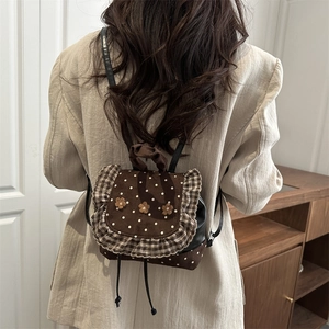 Retro floral mini backpack with polka dots and plaid ruffles worn by a model