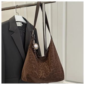 Detailed texture of leopard print tote bag with stylish baseball charm on side