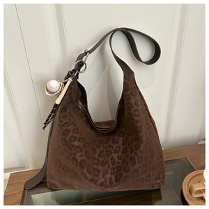 Detail of hobo shoulder bag with leopard print texture and baseball charm decoration
