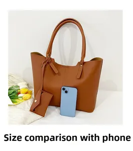 Size comparison of a large caramel tote bag with a smartphone and matching pouch