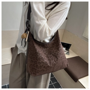 Macro view of leopard print hobo bag with adjustable strap and cute animal charm