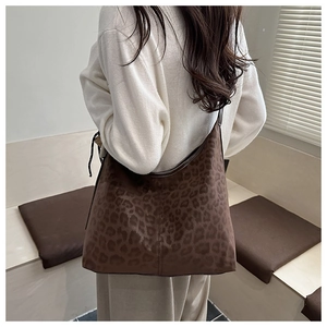 Detail view of large leopard print tote bag with soft suede texture and wide shoulder strap