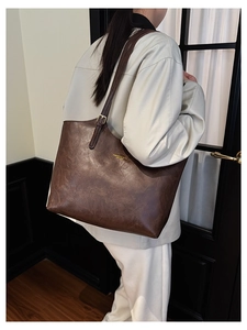 Detail of vintage brown leather tote bag showing spacious design and adjustable strap