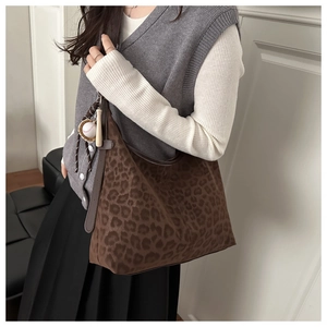 Detail of leopard print hobo bag with baseball charm on a model side view