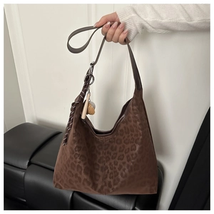 Detailed view of leopard print tote bag with soft suede texture and tassel charm detail
