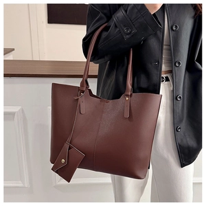 Detail of a large dark brown tote bag with a matching hanging coin purse and slim straps