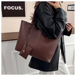 Detail of dark brown tote bag with matching coin purse shown on woman's shoulder