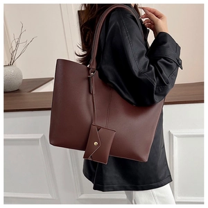 Close-up of large dark brown tote bag with a matching detachable envelope pouch charm