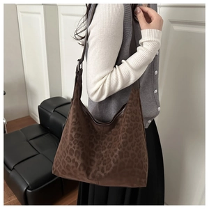 Detail of wide shoulder strap and leopard print texture on a large tote bag