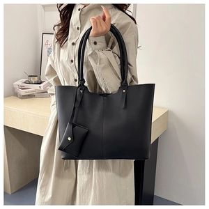 Detail of black large capacity tote bag with vertical stitching and small hanging pouch