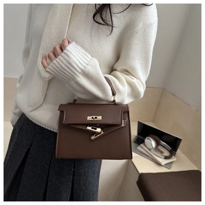 Brown lychee leather trapezoid handbag with metal twist lock and single handle detail