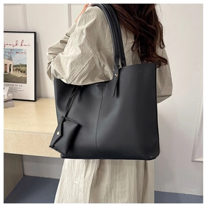 Rear view of black PU leather tote bag with small snap pouch worn by a model