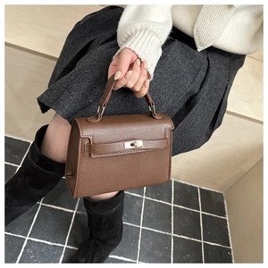 Classic brown textured leather Kelly bag featuring a top handle and gold-tone metal clasp