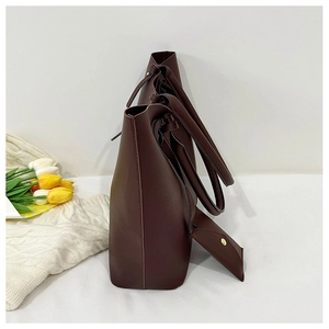 Side view of dark brown leather tote bag set with metal buckle detail and tulips