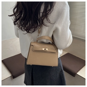 Detailed side view of khaki crossbody bag with classic metal lock and leather texture