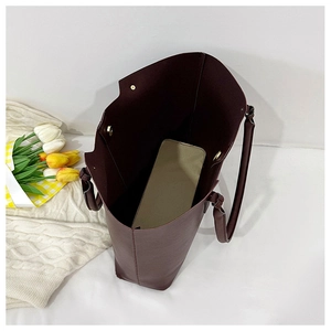 Detail view of large burgundy tote bag interior with magnetic closure and inner pouch