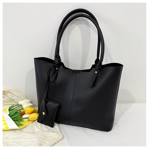 Detail of black large capacity tote bag with matching small coin pouch on white background