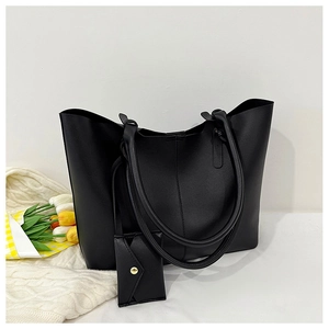 Detailed view of large black tote bag with long handles and matching mini pouch bag