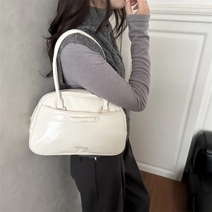 Minimalist cream white semi-circle leather tote bag with elegant bow detail on shoulder